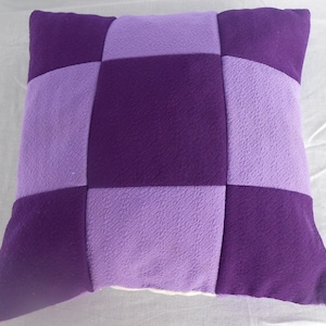 May include: Purple and lavender checkered throw pillow with a soft, plush texture.