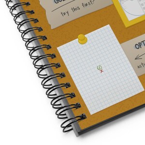 Detail shot of front cover of the Graphic Design Reference Notebook, showing illustration and background details.