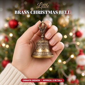 Può includere: Una piccola campana natalizia in ottone con un design ornato e dettagliato e un manico decorativo. La campana presenta motivi complessi attorno al bordo e al corpo, misurando circa 5 cm di altezza come indicato nel testo.