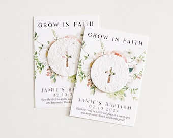 May include: Two white cards with floral designs and the text "Grow in Faith". Each card has a small, round, white seed paper with a cross design. The text "Jamie's Baptism" and the date "02.10.2024" are printed on the cards.
