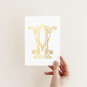 Op de afbeelding: Een gouden folie monogram print met de letters "M" en "Y" in een decoratief schrift.