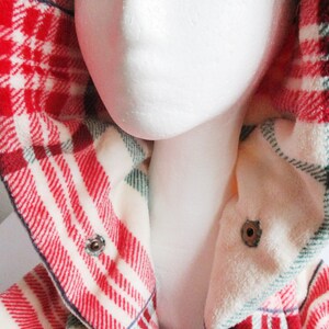 May include: Red and white checked flannel shirt with a green and white checked lining. The shirt has a hood and a button fastening.