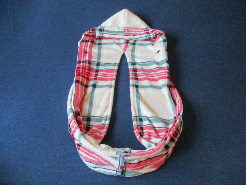 May include: A white infinity scarf with a red, blue and white plaid pattern.