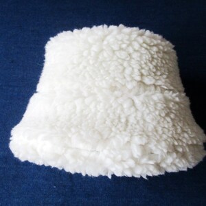 Puede incluir: Una pantalla de l&aacute;mpara blanca y esponjosa hecha de un material suave y peludo.