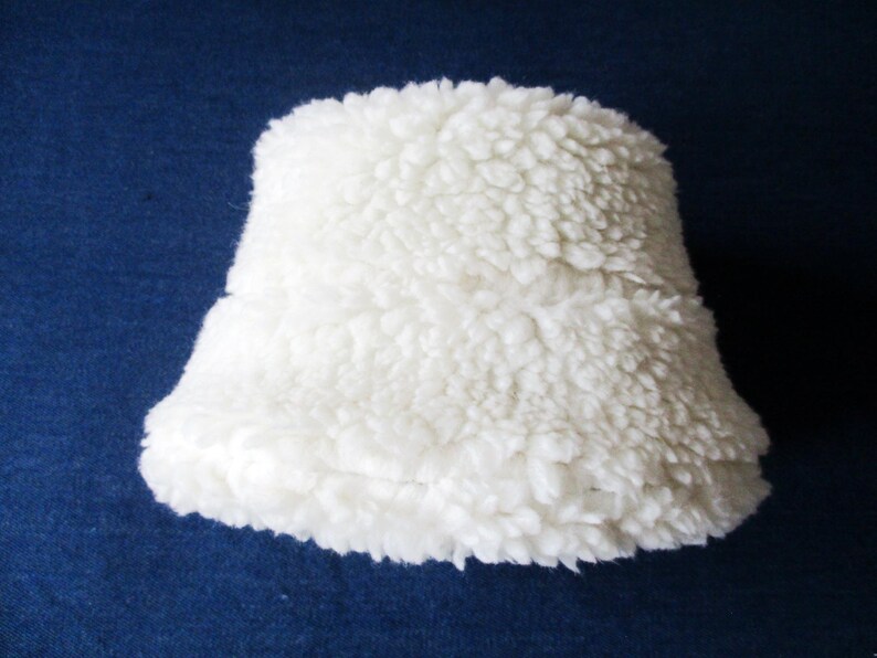 Puede incluir: Una pantalla de l&aacute;mpara blanca y esponjosa hecha de un material suave y peludo.