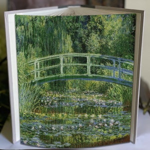 May include: A book cover featuring a painting of a green bridge over a pond with water lilies. The bridge is made of wood and has a white railing. The pond is surrounded by green trees and bushes.