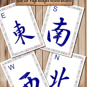 May include: Four white square tiles with blue Chinese characters and a black border. The characters are East, South, West, and North. The tiles are surrounded by a colorful border of red, green, and white.