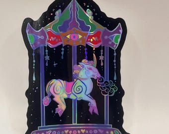 Puede incluir: Una pegatina holográfica con un diseño de carrusel. El carrusel tiene un fondo negro con un unicornio y un techo colorido. El unicornio es una mezcla de colores pastel, y el techo está a rayas verdes, moradas y rojas.