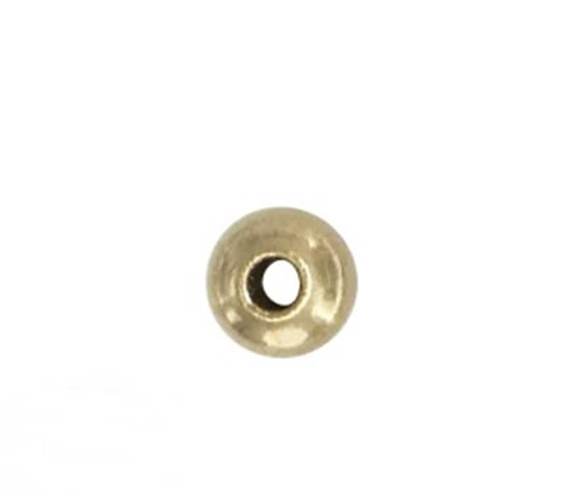 May include: A single gold-colored round bead with a hole in the center.