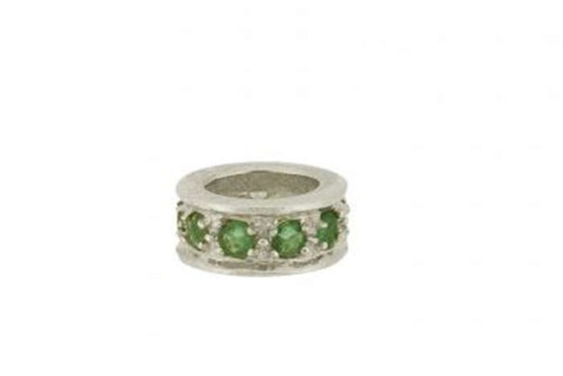 May include: A silver ring with a band of green gemstones.