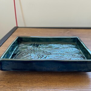 Plato rectangular de cerámica con la imagen de un correcaminos.