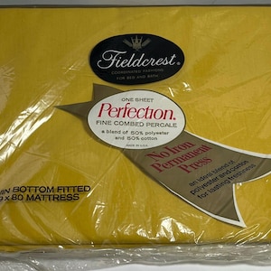 May include: A packaged, yellow fitted sheet for a long twin mattress. The packaging includes labels with the brand name "Fieldcrest" and the text "Perfection. Fine Combed Percale." The sheet fits a 39 x 80 inch mattress.