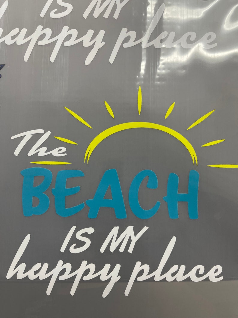 Pu&ograve; includere: Una grafica bianca su sfondo grigio con un sole giallo e il testo "The Beach is my happy place".