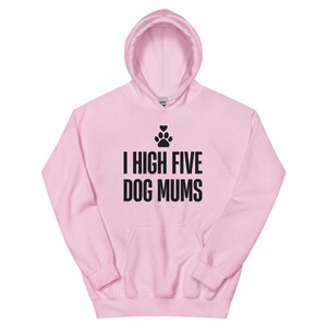 May include: A light pink hooded sweatshirt featuring a black graphic print on the chest. The design includes a small paw print topped with a heart, followed by the text I HIGH FIVE DOG MUMS in a bold, sans-serif, black capital font.