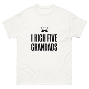 May include: A white short-sleeved t-shirt featuring a black graphic of round eyeglasses and a mustache above the text I HIGH FIVE GRANDADS printed in a bold, sans-serif font centered on the chest area of the garment.