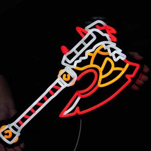 May include: A neon sign shaped like a battle axe with a white handle featuring red diagonal stripes. The axe head is outlined in bright red neon with internal yellow and white glowing details, creating a sharp, angular design against a dark background.