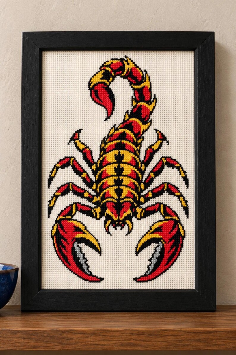 Straight-on view of the finished Scorpion Cross Stitch in a black frame on a wooden shelf