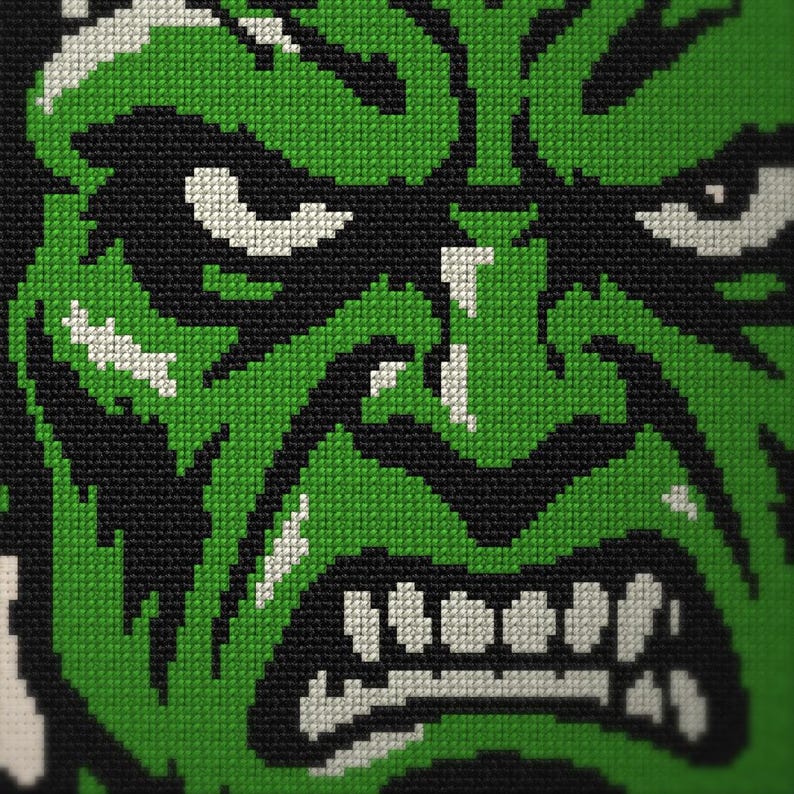 Puede incluir: Un bordado de punto de cruz que muestra un primer plano de un personaje de piel verde con el ce&ntilde;o fruncido, ojos intensos y dientes descubiertos. El dise&ntilde;o utiliza hilo verde vibrante, negro y blanco para crear un retrato pixelado y contrastado.