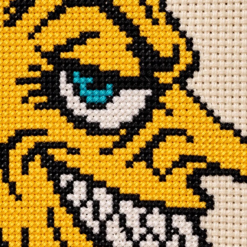 Macro of the stitched moon face with sharp teeth and a teal eye