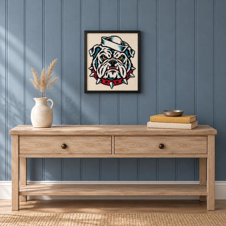 Framed sailor bulldog tattoo flash cross stitch on a wall