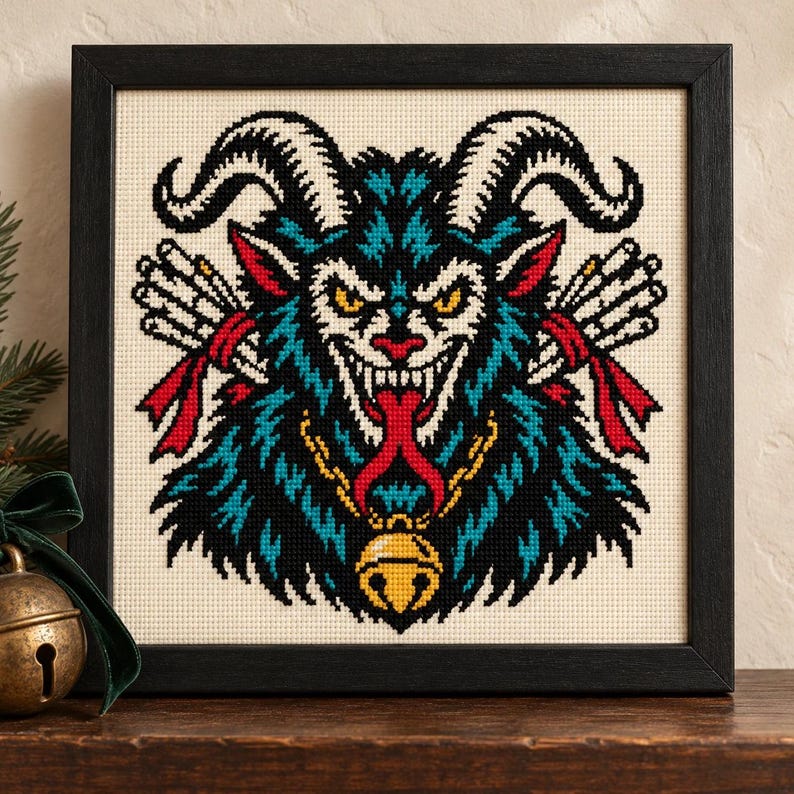 Straight-on view of the finished Krampus Cross Stitch in a black frame on a wooden shelf