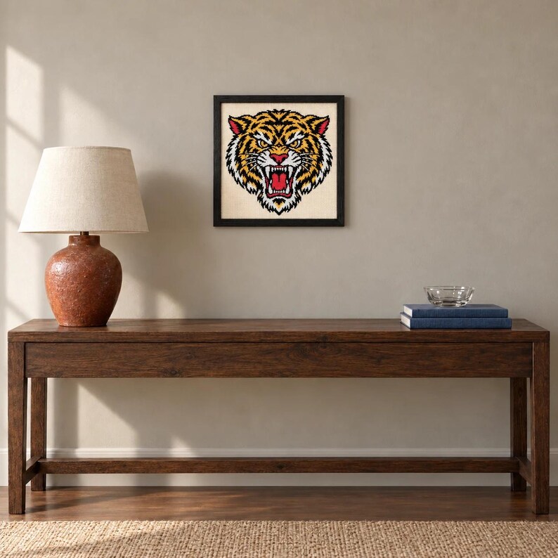 Framed roaring tiger tattoo flash cross stitch on a wall