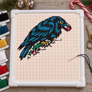 Raven wreath cross stitch in progress in a Q-snap frame