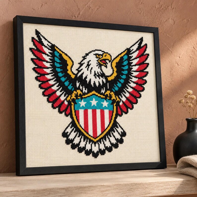 Eagle cross stitch in a black frame on a shelf at an angle