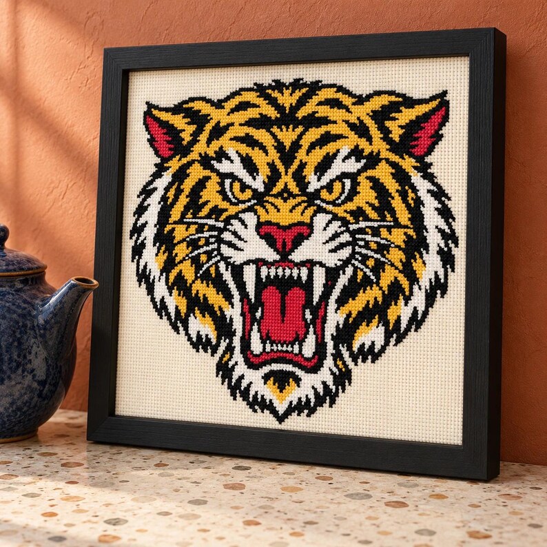 Tiger cross stitch in a black frame on a shelf