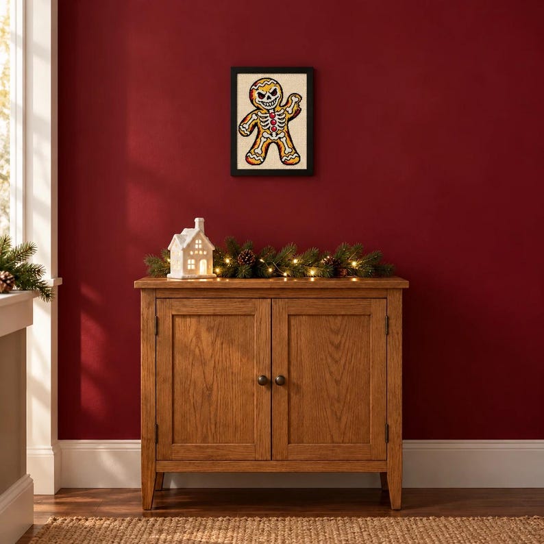 Framed gingerbread skeleton cross stitch on a wall