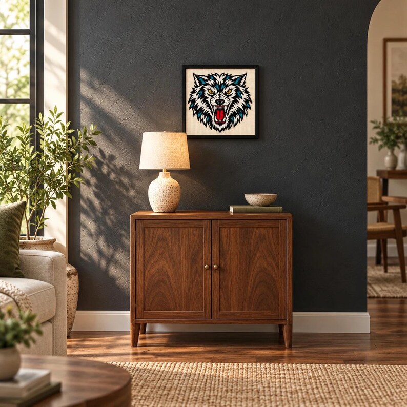 Framed snarling wolf head tattoo flash cross stitch hanging on a wall