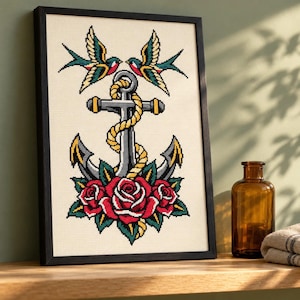 Anchor and swallows cross stitch in a tall black frame on a shelf