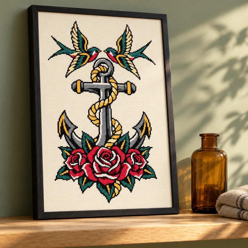 Anchor and swallows cross stitch in a tall black frame on a shelf