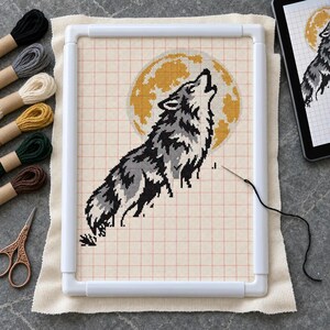 Howling wolf cross stitch in progress in a Q-snap frame