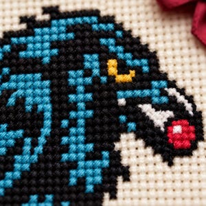 Macro of the stitched raven head and red berry