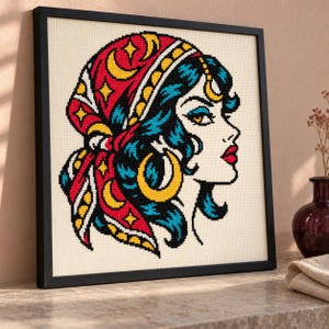 Fortune teller cross stitch in a black frame on a shelf