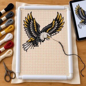 Eagle and snake cross stitch in progress in a Q-snap frame