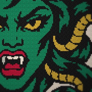 May include: A cross-stitch embroidery piece featuring a green-skinned character with yellow horns, sharp white fangs, and bright red lips. The design is set against a black background, with the character's face rendered in detailed green stitches.