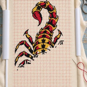 Scorpion cross stitch in progress in a Q-snap frame
