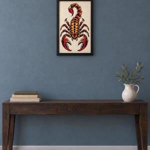 Framed scorpion tattoo flash cross stitch on a wall