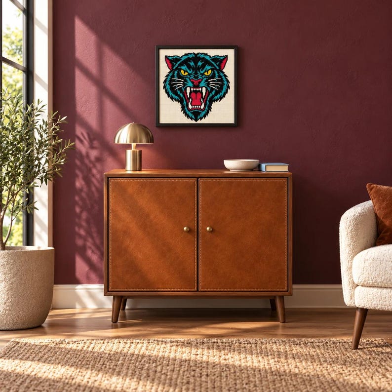 Framed black panther tattoo flash cross stitch hanging on a wall