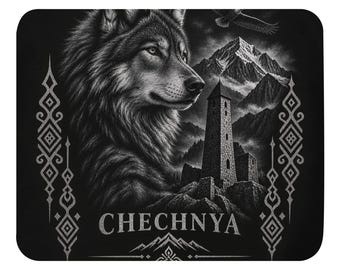May include: A rectangular black mousepad featuring a detailed grayscale illustration of a wolf, a stone tower, and mountain peaks. The word CHECHNYA is printed in white at the bottom, flanked by vertical geometric patterns on both sides.