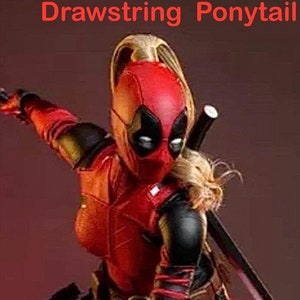 May include: A red and black action figure of a female superhero with a blonde ponytail. The figure is wearing a red and black suit with a black mask and a red belt. The figure is holding a sword in her right hand and a gun in her left hand. The figure is standing in a fighting pose.