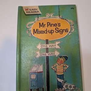 May include: A vintage Wonder Books Easy Reader children's book titled Mr. Pine's Mixed-up Signs by Leonard Kessler. The green cover features an illustration of a person and a dog standing by a signpost with two One Way signs and a mailbox.