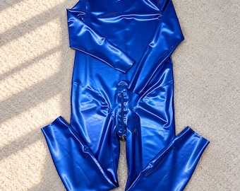 May include: A long-sleeved, full-length bodysuit in a vibrant, glossy royal blue finish. The garment features a high mock neck collar and a central vertical zipper that extends from the mid-torso down to the crotch area, creating a sleek silhouette.