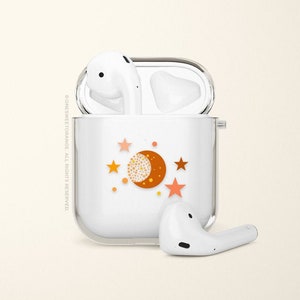 May include: White wireless charging case with a moon and stars design. The case is open and the two white earbuds are visible.