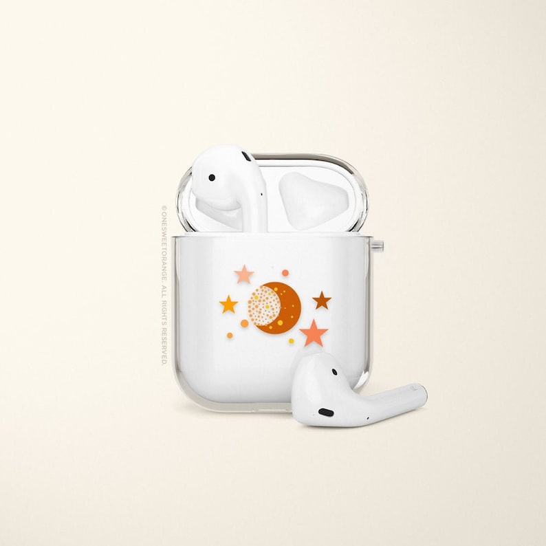 May include: White wireless charging case with a moon and stars design. The case is open and the two white earbuds are visible.