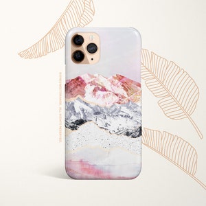 May include: A phone case with a pink, white, and gray mountain landscape design. The case has a clear back and a white border. The phone case is on a white background.