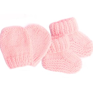 May include: A set of pink knitted baby booties and a matching hat. The booties have a fold-over cuff and the hat is a simple beanie style.