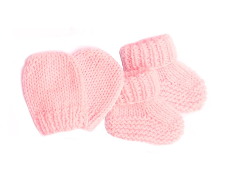 May include: A set of pink knitted baby booties and a matching hat. The booties have a fold-over cuff and the hat is a simple beanie style.